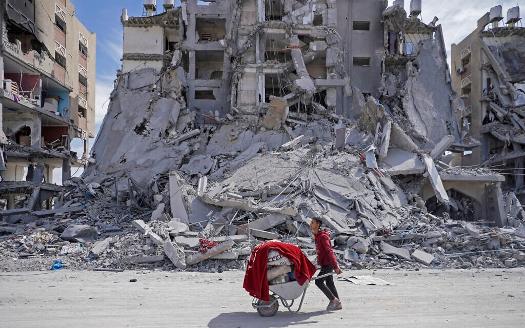 A displaced Palestinian man pushes a wheelbarrow in Khan Younis in the southern Gaza Strip on March 14, 2024. (AFP)