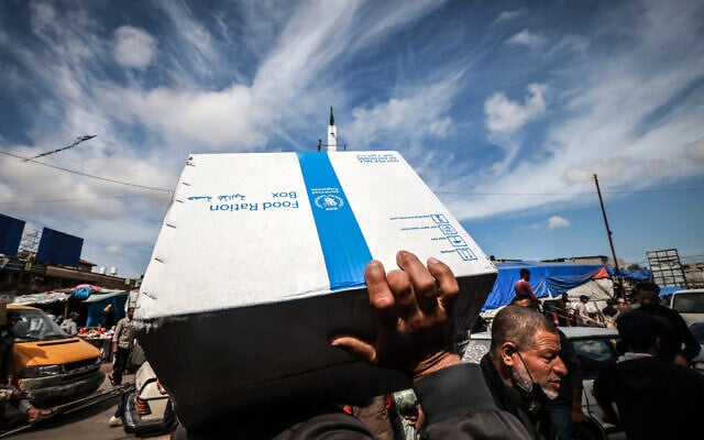 Displaced Palestinians carry a box of food rations provided by the World Food Programme (WFP) at a makeshift street market in Rafah in the southern Gaza Strip on March 14, 2024. (Mohammed Abed/AFP) Displaced Palestinians carry a box of food rations provided by the World Food Programme (WFP) at a makeshift street market in Rafah in the southern Gaza Strip on March 14, 2024. (Mohammed Abed/AFP)