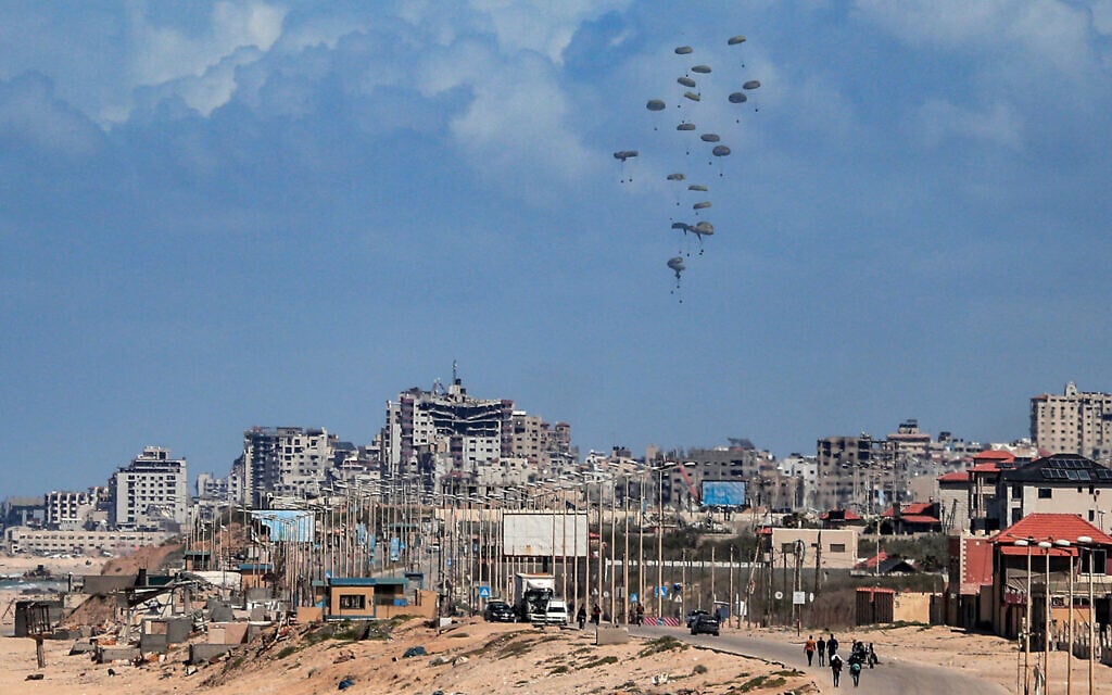 Parachutes attached to parcels of humanitarian aid are airdropped over Gaza City on March 15, 2024 (AFP)