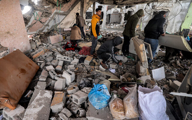 People search the rubble and debris of a building that was hit by Israeli strike in the southern Gaza Strip, March 19, 2024 (MOHAMMED ABED / AFP) People search the rubble and debris of a building that was hit by Israeli strike in the southern Gaza Strip, March 19, 2024 (MOHAMMED ABED / AFP)