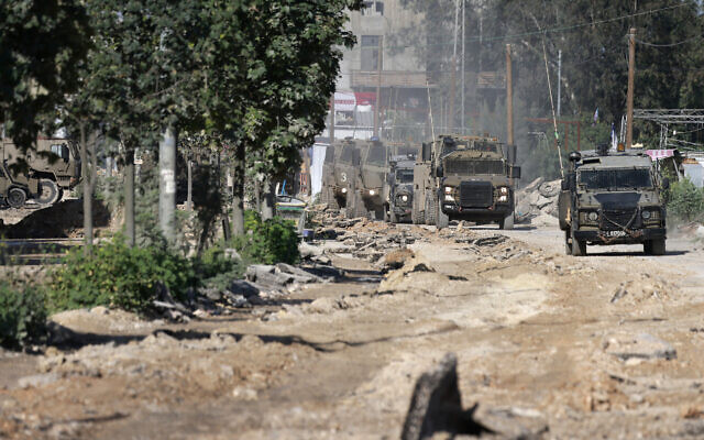 File - An armored IDF convoy leaves after a raid at the Nur Shams camp near Tulkarem in the northern West Bank on March 21, 2024. (Jaafar Ashtiyeh/AFP)