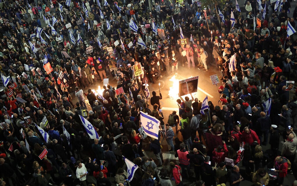 Relatives and supporters of Israeli hostages held in Gaza since the October 7 attacks by Hamas hold placards and wave Israeli flags during a demonstration in front of the Defense Ministry in Tel Aviv, on March 23, 2024. (Jack Guez/AFP)