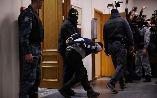 A man suspected of taking part in the attack of a concert hall that killed 137 people is escorted by Russian law enforcement officers prior to his pre-trial detention hearing at the Basmanny District Court in Moscow on March 24, 2024. (Photo by Tatyana Makeyeva/AFP)