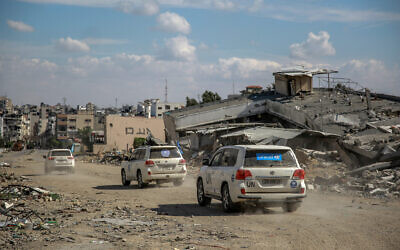 UN vehicles drive around buildings destroyed in previous Israeli strikes Gaza City, on March 25, 2024. (AFP)