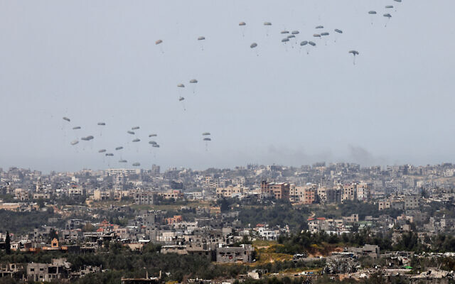 This picture taken from Israel's southern border with the Gaza Strip shows a military aircraft releasing parachutes of humanitarian aid over the enclave on March 27, 2024. (JACK GUEZ / AFP)