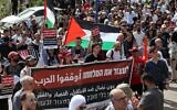 Protesters deploy a banner and wave Palestinian national flags during a rally marking the 48th anniversary of Land Day, in the Arab-Israeli town of Deir Hanna in the northern Galilee region on March 30, 2024. (AHMAD GHARABLI / AFP)