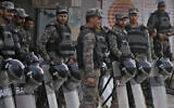 Paramilitary troops stand guard with riot gear to ensure security following attacks by a Muslim mob angry over allegations that a Christian man had desecrated the Quran near Faisalabad, Pakistan, Thursday, Aug. 17, 2023.   (AP/K.M. Chaudary)