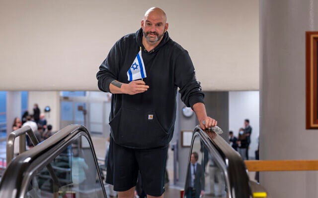 Sen. John Fetterman, D-Pa., holds a small Israeli flag as he heads to the chamber for a vote, at the Capitol in Washington, January 25, 2024. (AP Photo/J. Scott Applewhite)