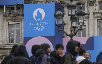 Youth gather at Paris City Hall where a Paris 2024 Olympic sign is displayed in Paris, March 5, 2024. (Michel Euler/AP)