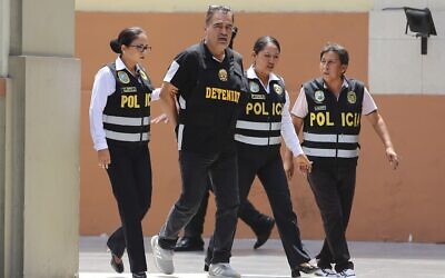 Officers escort Iranian Majid Azizi at police headquarters in Lima, Peru, March 8, 2024. (AP Photo/Manuel Castillo)