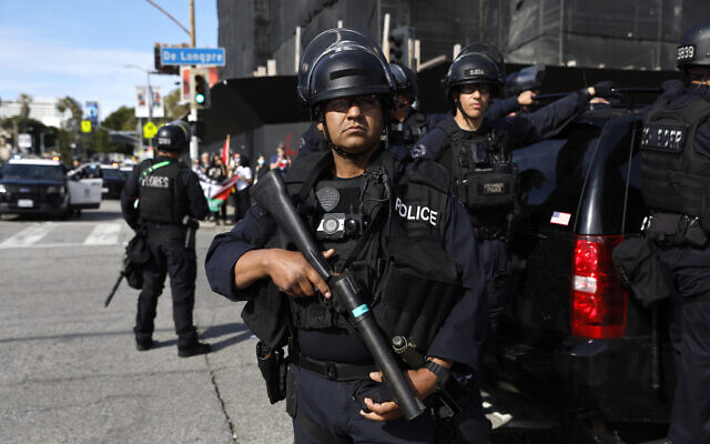 Law enforcement officers secure the arrivals of the 96th Academy Awards Oscars ceremony as hundreds of protesters demonstrate in support of Palestinians calling for a ceasefire in Gaza on Sunday, March 10, 2024, in the Hollywood section of Los Angeles. (AP/Etienne Laurent)