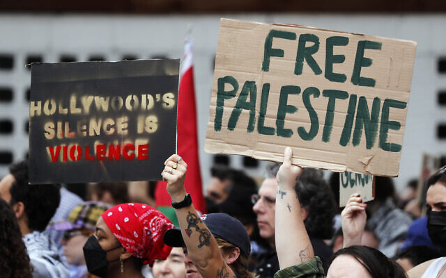 Protesters hold posters in support of Palestinians calling for a ceasefire in Gaza, near the Dolby Theatre where the 96th Academy Awards Oscars ceremony is held, Sunday, March 10, 2024, in the Hollywood section of Los Angeles. (AP/Etienne Laurent)