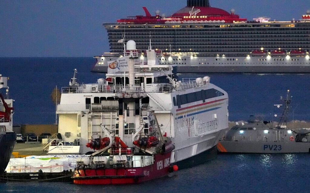 Aid packages are seen at left, on a platform near a docked ship belonging to the Open Arms aid group, center front, as it prepares to ferry some 200 tons of rice and flour directly to Gaza, at the port in Larnaca, Cyprus, March 11, 2024. (AP/ Petros Karadjias)