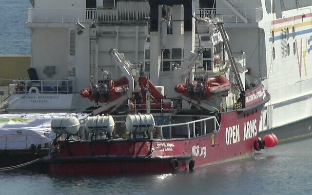 This image made from video shows a ship belonging to Spanish aid group Open Arms, background, and an aid barge docked at Larnaca port in Cyprus, March 11, 2024. (AP Photo)