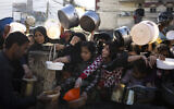 Palestinians line up for a meal in Rafah, Gaza Strip, on March 12, 2024. (AP Photo/Fatima Shbair)