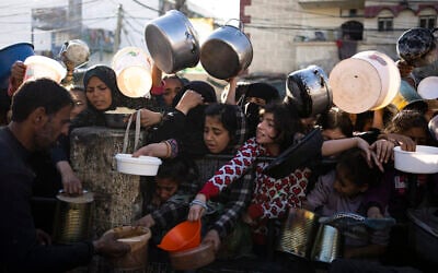 Palestinians line up for a meal in Rafah, Gaza Strip, on March 12, 2024. (AP Photo/Fatima Shbair)