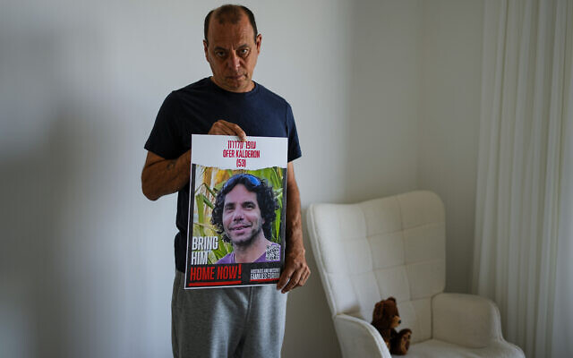 Nissan Kalderon poses with a photo of his only brother, Ofer, a hostage held in the Gaza Strip by the Hamas terror group, in Ramat Gan, March 13, 2024 (AP Photo/Ariel Schalit) Nissan Kalderon poses with a photo of his only brother, Ofer, a hostage held in the Gaza Strip by the Hamas terror group, in Ramat Gan, March 13, 2024 (AP Photo/Ariel Schalit)