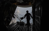 A member of US Air Force collects the cable after parachutes were dropped with humanitarian aid over the Gaza Strip, March 14, 2024. (AP Photo/Leo Correa)