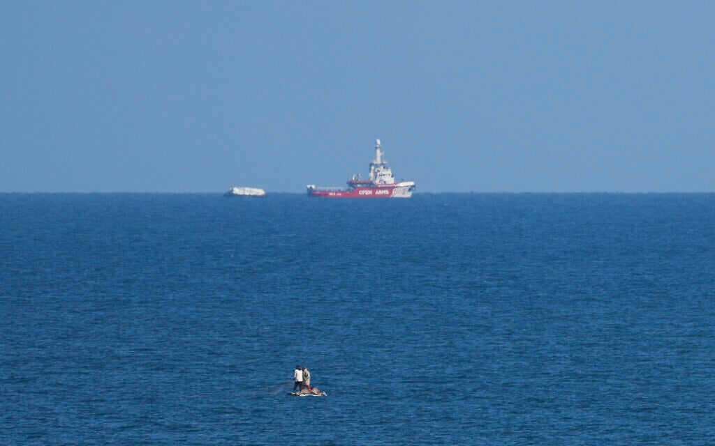 A ship belonging to the Open Arms aid group approaches the shores of Gaza towing a barge with 200 tons of humanitarian aid on Friday, March 15, 2024. (AP Photo/Abdel Kareem Hana)