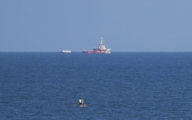 A ship belonging to the Open Arms aid group approaches the shores of Gaza towing a barge with 200 tons of humanitarian aid on Friday, March 15, 2024. (AP Photo/Abdel Kareem Hana)