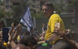Brazil's former president Jair Bolsonaro is surrounded by supporters after attending a campaign event launching the pre-candidacy of a mayoral candidate, in Rio de Janeiro, Brazil, March 16, 2024. (AP Photo/Silvia Izquierdo)