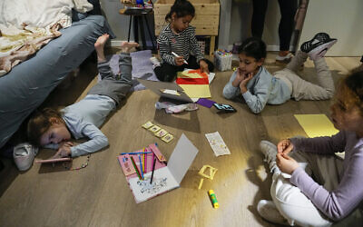 Israeli girls evacuated from Kiryat Shmona play in a room in a hotel in Tiberias, March 4, 2024. (AP Photo/Ariel Schalit)
