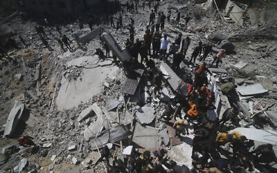 Palestinians look at a residential building destroyed in an Israeli strike in Rafah, Gaza Strip, Tuesday, March 20, 2024. (AP Photo/Hatem Ali)