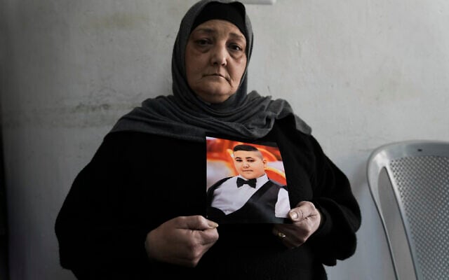 Rawiya Halhouli holds a photo of her slain son Rami Halhouli, in their house in Shuafat refugee camp in east Jerusalem, March 17, 2024. (AP Photo/Mahmoud Illean) Rawiya Halhouli holds a photo of her slain son Rami Halhouli, in their house in Shuafat refugee camp in east Jerusalem, March 17, 2024. (AP Photo/Mahmoud Illean)