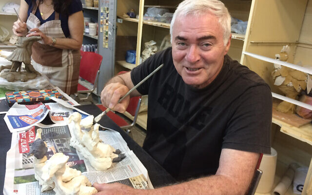 Amnon Sharon painting some of his clay sculptures depicting the torture he underwent as a prisoner of war in Syria, October 1973-June 1974. (Courtesy of Israel Disabled Veterans Organization)