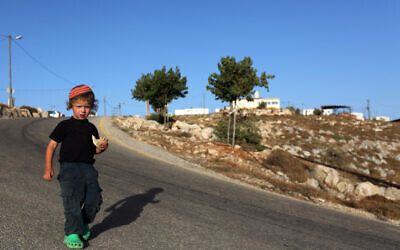 A young child poses for the camera at the illegal outpost of Ahiya, north east of the Shvut Rachel settlement in the West Bank, June 6, 2010. (Kobi Gideon/ FLASH90/ File)