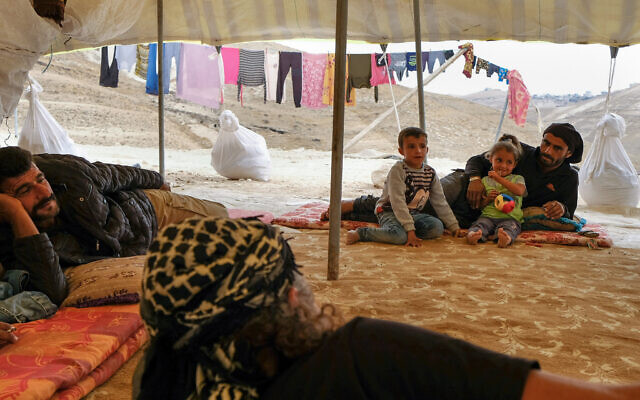 Illustrative: Bedouin men and children rest in a tent in a Judean desert village, October 26, 2019. (Sara Klatt/Flash90)