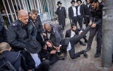Ultra-Orthodox men clash with police during a protest outside an army recruitment office in Jerusalem, March 4, 2024. (Chaim Goldberg/Flash90)