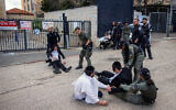 Haredi men clash with police during a protest outside the IDF recruitment office in Jerusalem, March 4, 2024. (Chaim Goldberg/Flash90)
