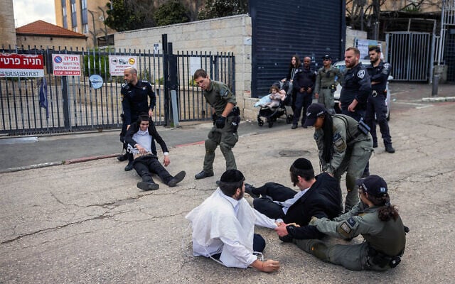 Haredi men clash with police during a protest outside the IDF recruitment office in Jerusalem, March 4, 2024. (Chaim Goldberg/Flash90) Haredi men clash with police during a protest outside the IDF recruitment office in Jerusalem, March 4, 2024. (Chaim Goldberg/Flash90)