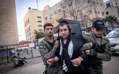 Illustrative: A Haredi man clashes with police during a protest outside an army recruitment office in Jerusalem, March 4, 2024. (Chaim Goldberg/Flash90)