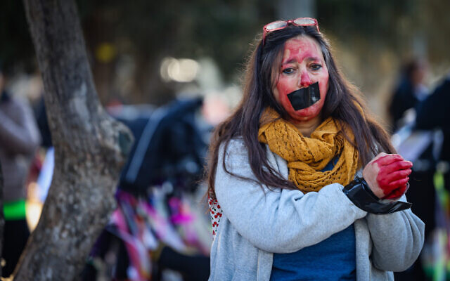 Activists protest for the release of Israeli hostages held in the Gaza Strip during the annual Jerusalem marathon, March 8, 2024. (Chaim Goldberg/Flash90)