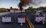 Families of hostages held by Hamas terrorists in Gaza and activists block Route 1 between Tel Aviv and Jerusalem, during a protest on March 8, 2024. (Yonatan Sindel/Flash90)