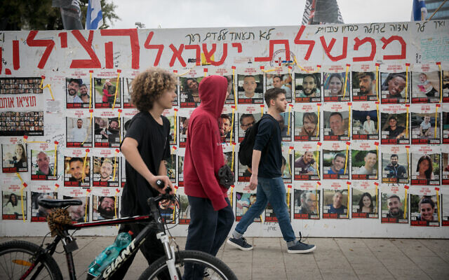 People walk by photographs of those still held by Hamas terrorists in Gaza, at 'Hostages Square' in Tel Aviv. March 14, 2024 (Miriam Alster/FLASH90) People walk by photographs of those still held by Hamas terrorists in Gaza, at 'Hostages Square' in Tel Aviv. March 14, 2024 (Miriam Alster/FLASH90)