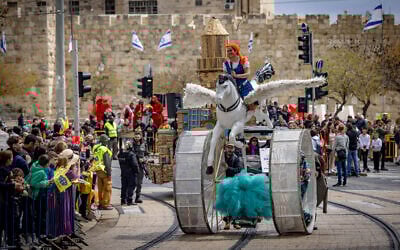 Onlookers watch the Purim parade in Jerusalem, March 25, 2024 (Yonatan Sindel/Flash90)