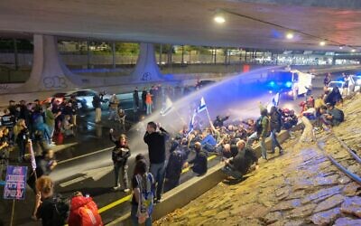 Police use water cannons on protesters blocking the Ayalon Highway in Tel Aviv on March 9, 2024. (Adar Eyal/Israeli Pro-Democracy Protest Movement)