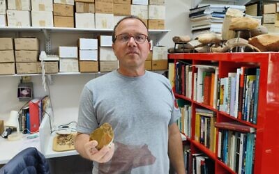 Prof. Ran Barkai holding a prehistoric stone tool, in his office at Tel Aviv University, on February 28, 2024. (Gavriel Fiske/Times of Israel) Prof. Ran Barkai holding a prehistoric stone tool, in his office at Tel Aviv University, on February 28, 2024. (Gavriel Fiske/Times of Israel)