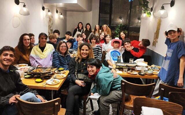 Students from Hannah Senech Community Day School at Sima restaurant in Jerusalem, along with their accompanying teachers and guides, on March 25, 2024. (Gavriel Fiske/TOI)