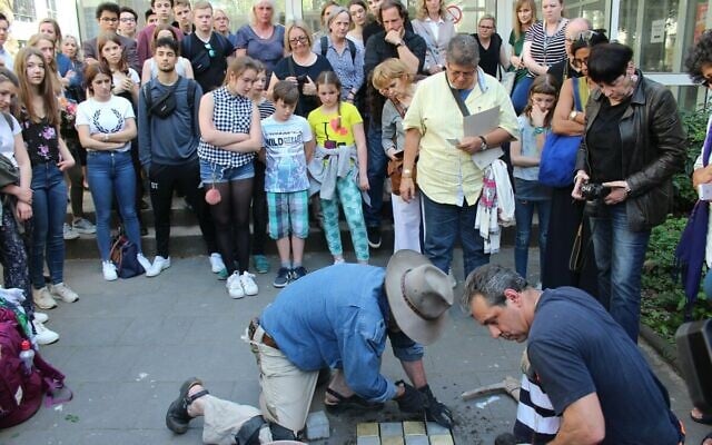 At the Königin Luise Schule in Cologne, Germany, students watch as 'Stumbling Stone' memorials are installed for Holocaust victims who were expelled by the school during Nazi rule (courtesy)