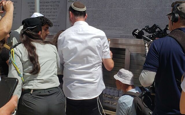 Families light memorial candles for their loved ones just before the bar and bat mitzvah ceremonies for children of fallen IDF soldiers at the Western Wall on April 3, 2024 (Maya Zanger-Nadis/Times of Israel)