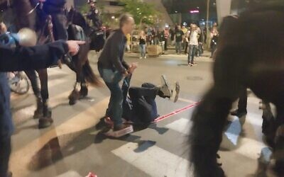 A man is knocked over by a police horse as protests in Tel Aviv are dispersed, April 6, 2024. (Iddo Schejter/Times of Israel)