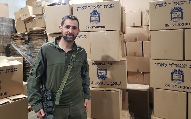 Yedidya Harush stands next to boxes of matzah made in his matzah bakery in Netivot on April 8, 2024 (Credit: Maya Zanger-Nadis/Times of Israel).