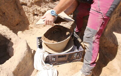 Opening the large basalt bowls used to inter a broken ivory vessel 6,000 years ago near Beersheva.(Davida Dagan/IAA)
