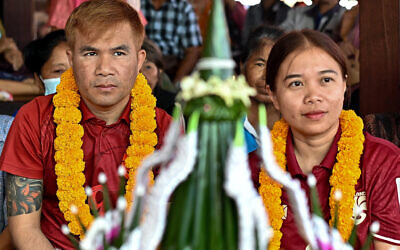 Freed Thai couple Boonthom Pankhong (L) and Natthawaree Munkan (R), who were held hostage by Hamas following the October 7 attack on Israel, take part in a traditional welcoming ceremony for their safe return to Thailand, at their house in Thailand's northeastern Udon Thani province on December 6, 2023. (Photo by Manan VATSYAYANA / AFP)