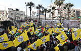 Palestinians lift flags during a rally marking the 59th anniversary of the Fatah movement foundation in Ramallah in the West Bank on December 31, 2023. (Zain JAAFAR / AFP)