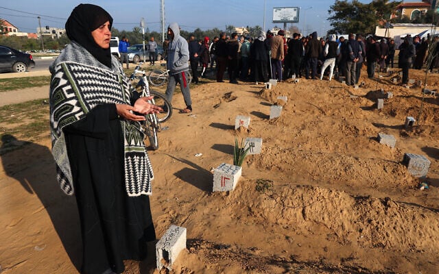 Illustrative - A Palestinian woman prays by a relative's tomb as others bury their dead following overnight Israeli airstrikes, at a cemetery in east Khan Younis in the southern Gaza Strip, February 26, 2024. (Photo by SAID KHATIB / AFP) Illustrative - A Palestinian woman prays by a relative's tomb as others bury their dead following overnight Israeli airstrikes, at a cemetery in east Khan Younis in the southern Gaza Strip, February 26, 2024. (Photo by SAID KHATIB / AFP)